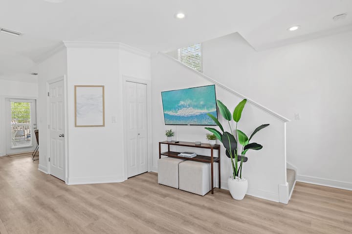 Dhomë ndenjjeje e ndritshme me televizor inteligjent - e hapur për kuzhinën dhe ambientet e ngrënies.