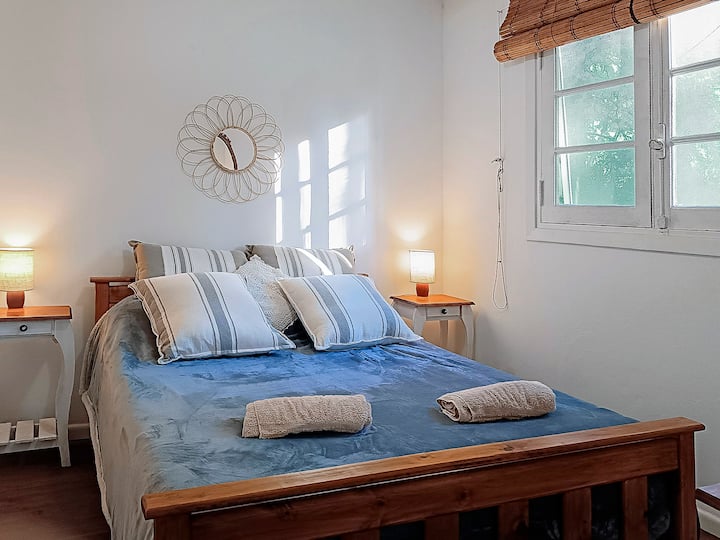 غرفة نوم رئيسية بإطلالات على الحديقة.