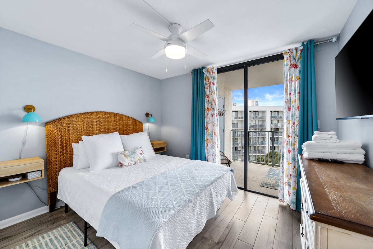 Queen size bed overlooking pool and lagoon