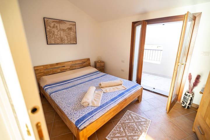 卧室配有带记忆的床垫和枕头、衣橱和衣架，可俯瞰大理石地板的露台，可俯瞰泳池。