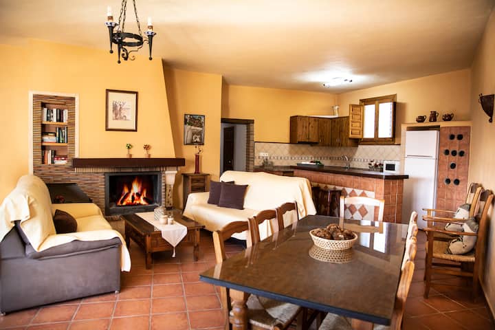 Chumba cha kulia chenye nafasi kubwa chenye meko, kiyoyozi, meza kubwa ya kulia chakula na mandhari ya bwawa. Jiko lililo chini lenye baa ya Kimarekani.