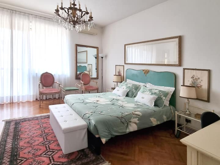 غرفة نوم أنيقة ومشرقة بسرير مزدوج. تخلق الألوان الزاهية والباستيل شعورًا بالهدوء، مما يدعو إلى الاسترخاء والراحة في بيئة راقية ومريحة.