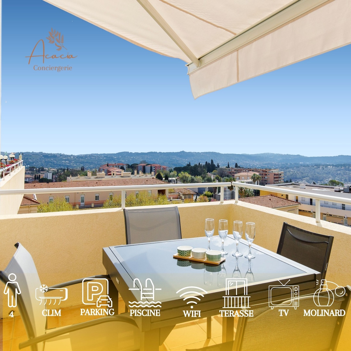 A terrace is featured with a table set for outdoor dining, accommodating four guests. Glassware is arranged on the table, and a view of the surrounding hills and cityscape can be seen in the background. An awning provides shade from direct sunlight.