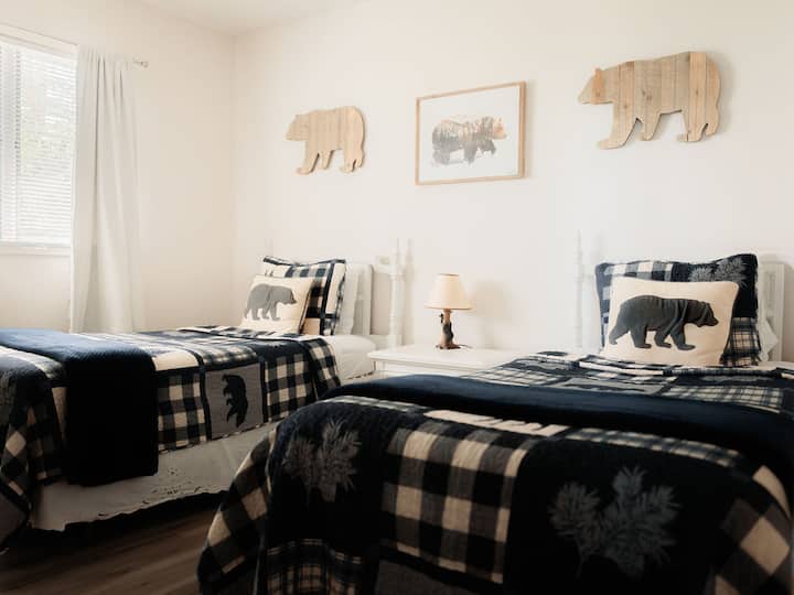 בחדר השינה הראשון יש שתי מיטות זוגיות וטלוויזיה חכמה.