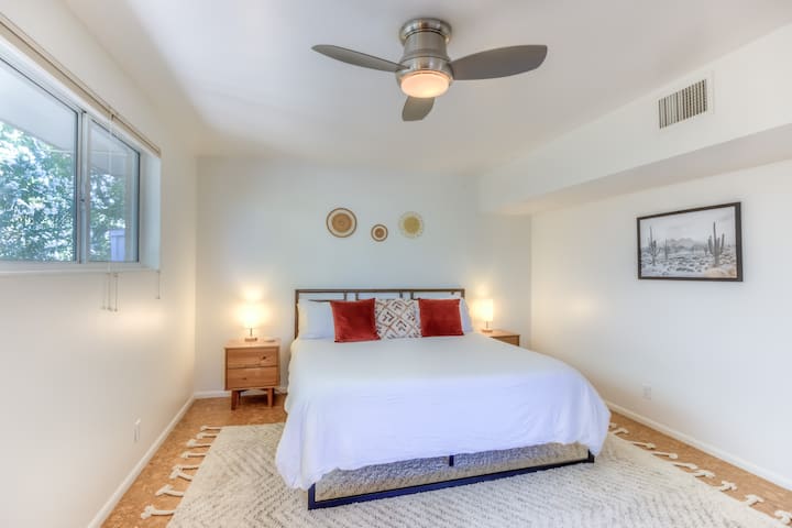 Large primary bedroom with king size bed, ceiling fan, walk-in closet and ensuite primary bathroom with open shower, soaking tub and double vanity.