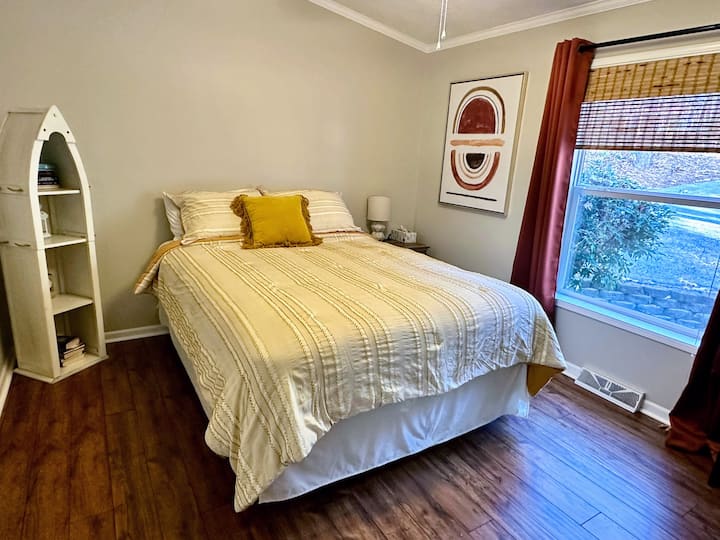 Chumba hiki cha kulala chenye starehe ni kizuri kwa ajili ya asubuhi yenye uvivu na mapazia ya kuzima, kuhakikisha usingizi wa utulivu. Ina televisheni, sehemu nzuri ya kukaa na rafu ya vitabu, inayotoa mapumziko ya amani ili kupumzika na kufurahia mazingira tulivu.