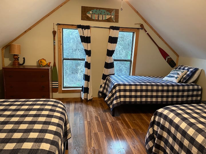 غرفة نوم في الطابق العلوي مع سريرين مفردين وسرير كوين وسرير كامل