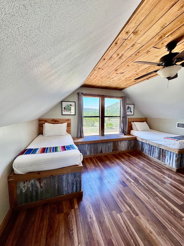 غرفة نوم في الطابق العلوي مع سريرين مفردين وسرير كوين