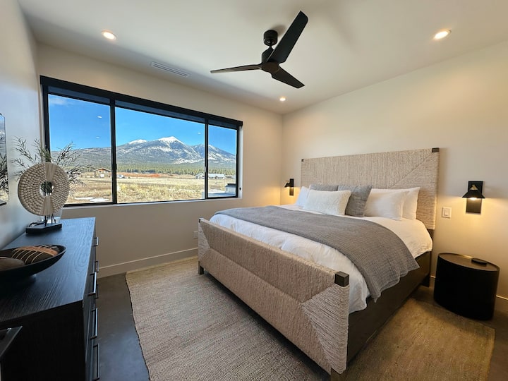 Guest bedroom with King sized bed, reading sconces,  43" 4k smart TV. Unobstructed beautiful views of Mt Humphreys. Large dresser for clothes storage. Bathroom located just outside door.