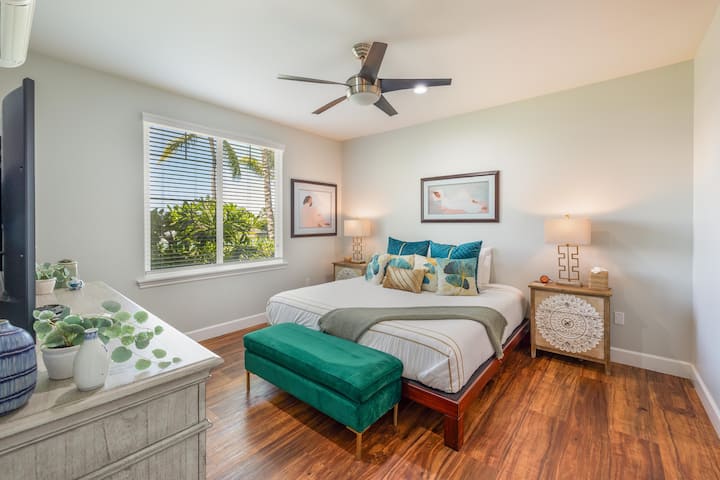 Despiértate en esta cama tamaño king con exuberantes vistas tropicales desde el dormitorio principal