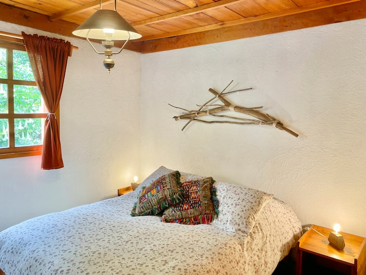 Hlavná izba vo veľkej zrube s manželskou posteľou.