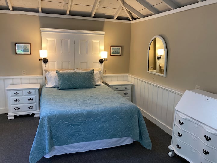 היכנסו דרך דלת הכניסה לחלל הצבוע והמעוצב החדש הזה, עם ראש המיטה המגניב הזה שעשוי משתי דלתות עתיקות! שפע של מקום אחסון זמין לבגדים, ושולחן המזכירות הזה משמש גם כחלל עבודה (אם אתם חייבים לעבוד).