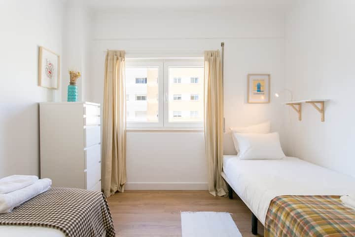 Dormitorio con 2 camas individuales con ventana con luz solar