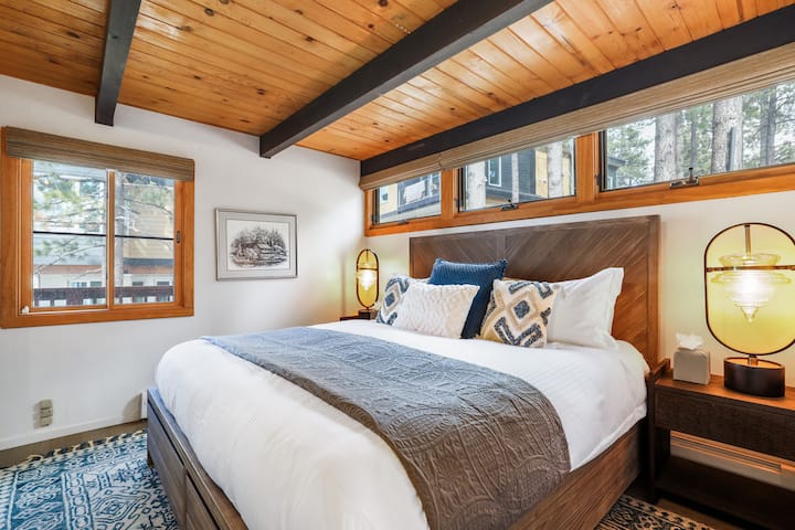 Acogedor dormitorio de invitados: cálidos detalles de madera y ropa de cama lujosa.