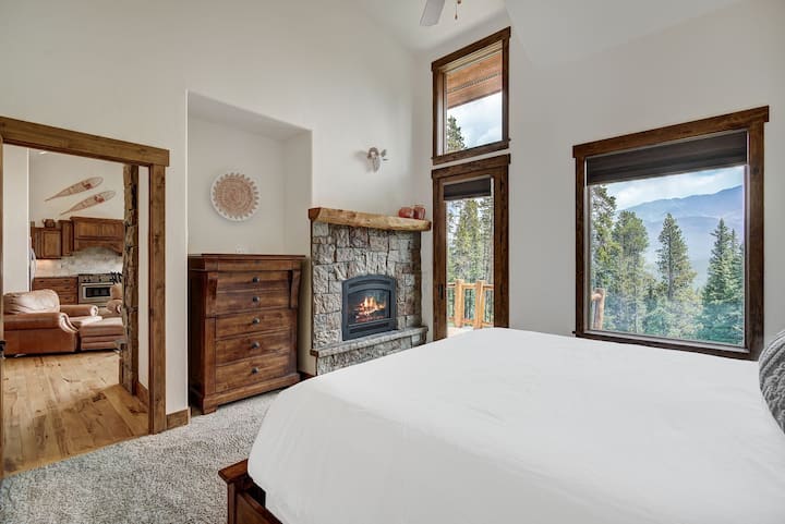 Primary bedroom with king sized bed, dresser, fireplace, and en-suite bathroom.