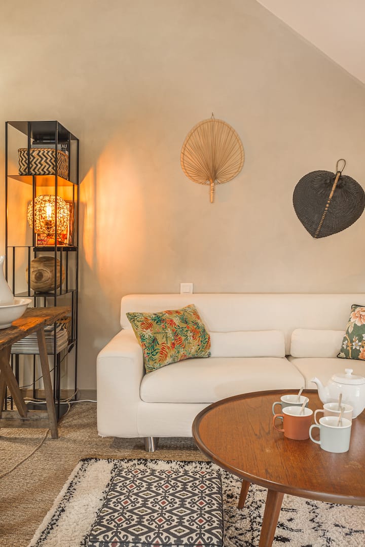 Coin salon telle une suite dans la "Master Room" de 30m2 et grande hauteur sous plafond. Poutres, chaux sur les murs, jonc de mer au sol...vous donneront une sensation de cocon pour un séjour "slow life". Ideal pour 1 couple avec enfants en bas âges.