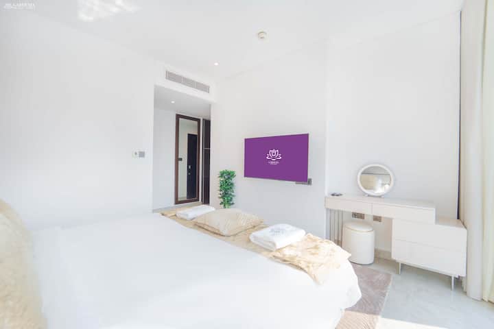 Chambre blanche avec un meuble télé moderne et des intérieurs minimalistes.
Lumineux, propre et conçu pour un confort reposant.