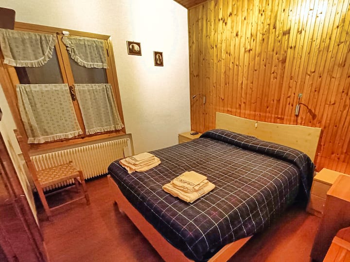 غرفة نوم رئيسية مع ألواح خشبية على الجدران