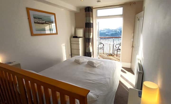 King sized bed, double patio doors opening onto balcony overlooking sea and beach