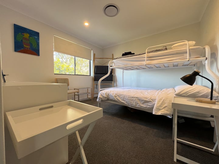 2 - ра спалня с удобни двойни и единични двуетажни легла, отопление с въздуховоди и изглед към листата.