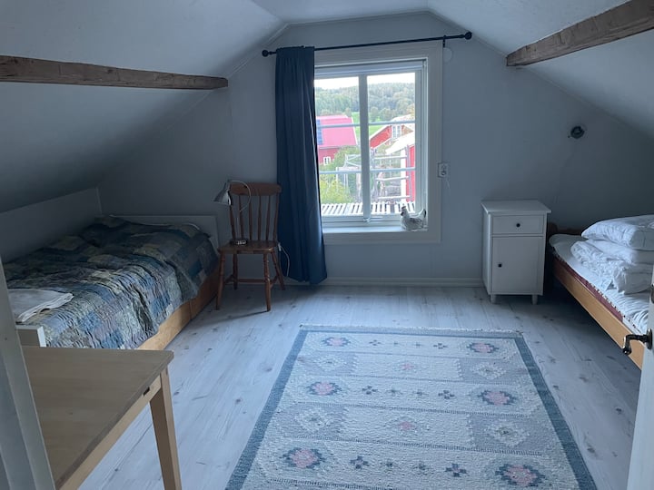 Stanza accogliente con soffitto spiovente al piano superiore con vista sul cortile. 