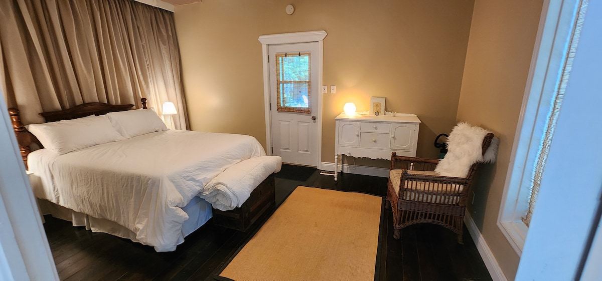 Cama tamaño queen, sábanas blancas de microfibra. Edredón adicional, ventilador de techo silencioso. Baño privado.