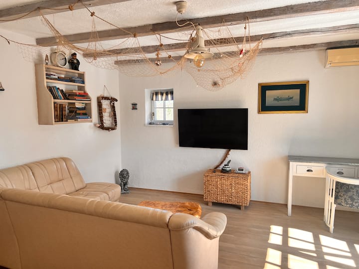 A spacious living room with a 55" flat screen.
There is also a large corner leather sofa that can be unfolded and turned into a large bed for two adults.
Here is a work area with a chair and a desk.
The speed of the wi-fi connection is about 300 Mbps