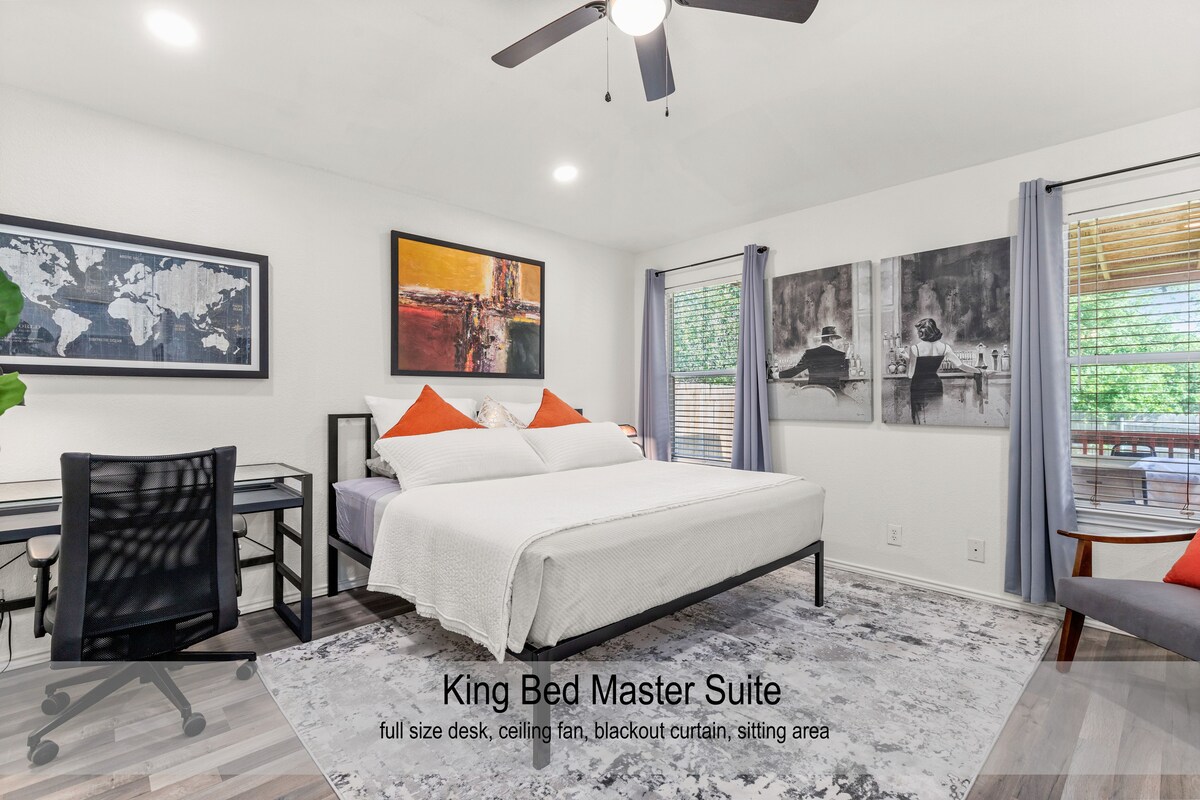 Suita kryesore King Bed e dekoruar me shije me hapësirë pune, hapësirë për t 'u ulur dhe një televizor Roku 4K 55 inç (nuk shfaqet)