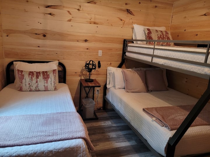 Bedroom 1 comfortably sleeps 3 guests, featuring a standalone twin-sized bed and a bunk bed with a full-size mattress on the bottom and a twin-size mattress on top. 