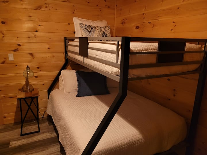 Bedroom 1 comfortably sleeps 3 guests, featuring a standalone twin-sized bed and a bunk bed with a full-size mattress on the bottom and a twin-size mattress on top. 