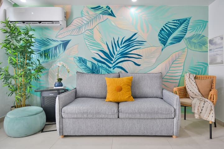 Svijetla i moderna dnevna soba s udobnom sofom na razvlačenje, pametnim televizorom i elegantnim dekorom - savršen za opuštanje nakon istraživanja Portorika.