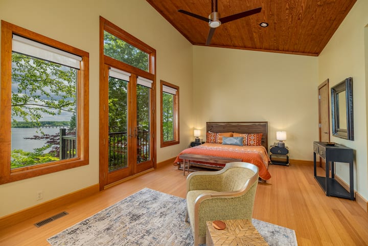 2nd floor primary bedroom with king bed, balcony, seating, large smart tv and ensuite bathroom