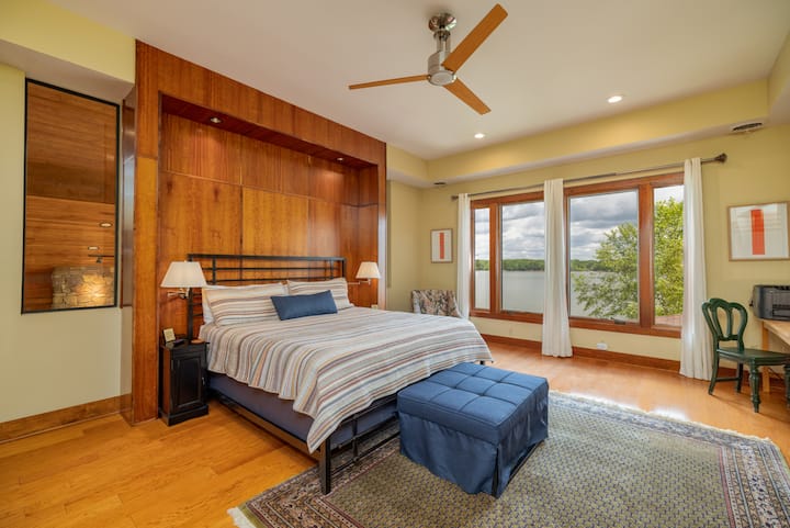 2nd floor primary bedroom with king bed, lake views, seating, desk with printer, large smart tv and ensuite bathroom.  This bedroom also has a pull ottoman into single bed.