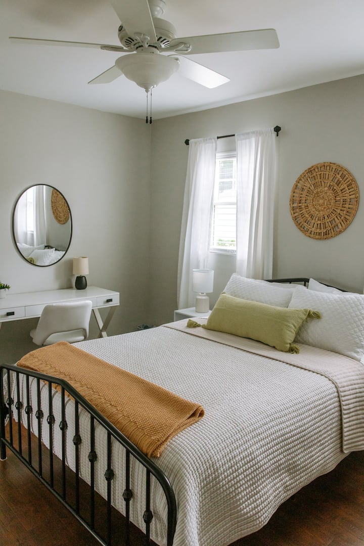 Master bedroom with workspace or vanity and walk-in closet.