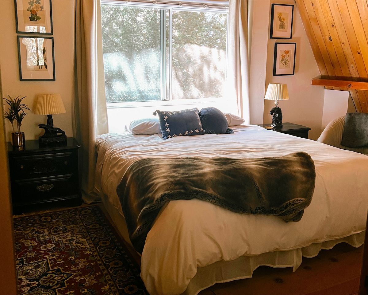 Primary bedroom overlooking the forest, includes a king bed and closet space