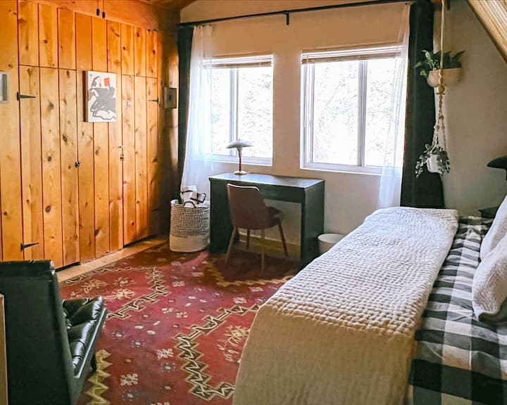 The writer's room: a loft room featuring a queen bed, closet space, cozy reading chair and yoga mats