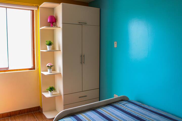 Chambre avec lit 2 places et penderie. Bon éclairage toute la journée.