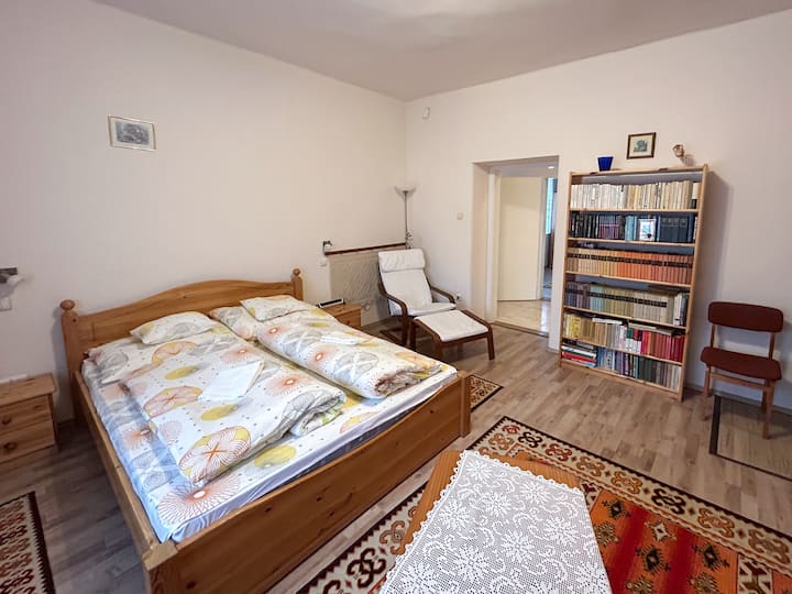 En el primer dormitorio, se proporciona una cama doble de 160 cm para mayor comodidad, y aquí es donde la estantería sirve para relajarse en el clima sombrío. El sillón es cómodo de leer, pero también es muy acogedor en la terraza cubierta.