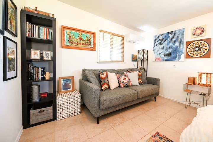 Მისაღები ოთახი კომფორტული ტახტით, წიგნების შერჩევით, ტაროს ბარათებითა და პორტატული Bluetooth დინამიკით, რომ სტუმრობისას საკუთარი მუსიკით დატკბეთ