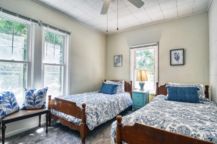 两张单人床：梳妆台和衣柜。百叶窗。  