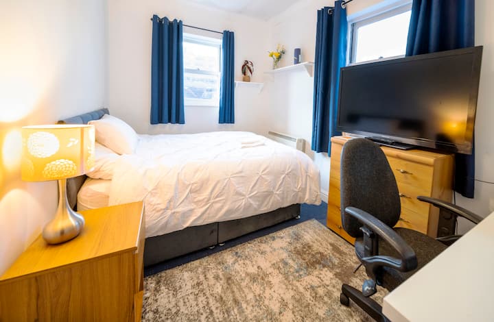 Კომფორტული ორადგილიანი საწოლი და მეხსიერების ქაფის ლეიბი,ახლახან შეძენილი ახალი. Ტელევიზორი Amazon Fire Stick-ისა და Freeview არხებით. Დიდი სამუშაო მაგიდა სარკეებით,მიკროტალღური ღუმელით,ჩაით,ყავით, ჭიქითა და მინით. სამუშაო სივრცის გამოსაყენებლად საოფისე სკამი.