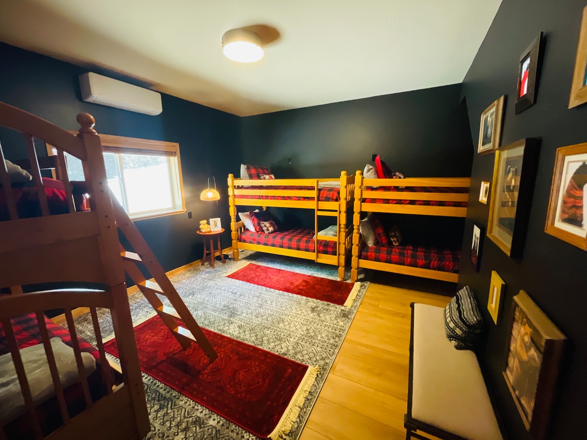 楼下，游戏室外，是我们舒适的双层床房，可容纳6人，非常适合孩子、表亲或朋友入住。 配备水牛格纹床上用品、柔软的地毯和闲逛空间，让您随时可以过夜，充满露营小屋的魅力。
