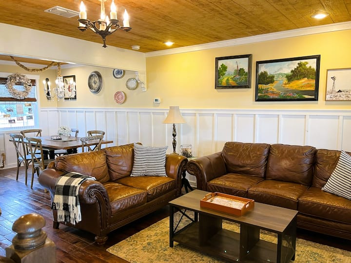 المعيشة في الطابق الأول، مع منطقة لتناول الطعام في الخلفية. تقع هذه الغرفة قبالة الشرفة الأمامية الكبيرة.