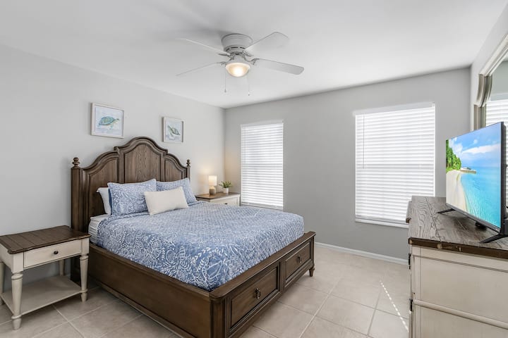 Bedroom 3 offers a queen sized bed, smart TV, mirror, closet and dresser for clothing storage. Big, bright windows offer lots of natural light and a view of palm trees out front! 