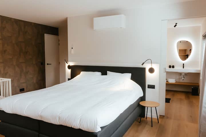 Хотелска кутија со брачен кревет со горен дел, клима уред за ладење и греење, сопствена бања со тоалет, мијалник со осветлено огледало и туш за раце и дожд.