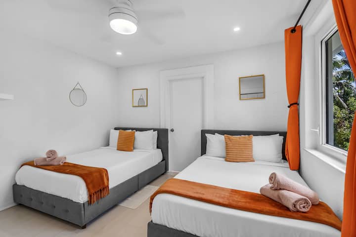 橙色卧室位于二楼，配备两张舒适的全尺寸床、宽敞的衣柜和独立的步入式套房卫生间。 遮光窗帘确保您在这个充满活力、设施齐全的房间里享受宁静和放松的住宿体验。