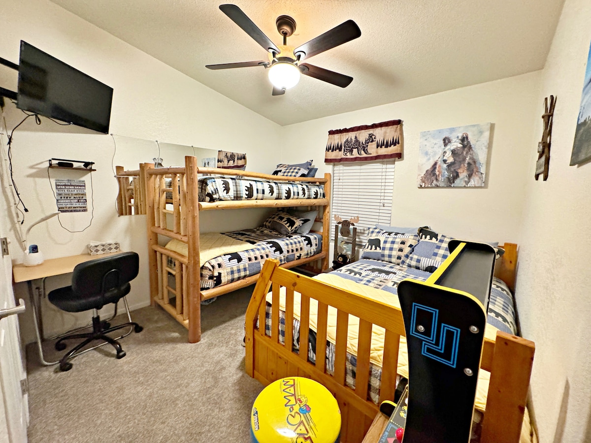 The bunk room at Almost Bearadise has two twin log beds, a full plush mattress with a twin trundle, and a movable desk for remote work. Kids will love the mini PAC-Man arcade—making this room a fun, cozy favorite for the whole family!