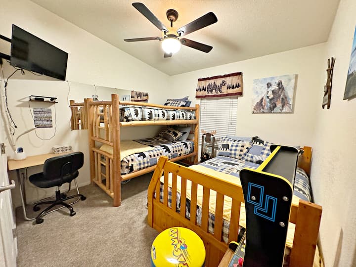 The bunk room at Almost Bearadise has two twin log beds, a full plush mattress with a twin trundle, and a movable desk for remote work. Kids will love the mini PAC-Man arcade—making this room a fun, cozy favorite for the whole family!