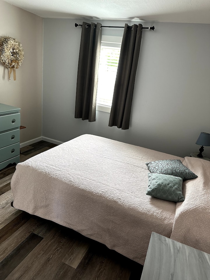 Lit queen size avec commode et placards. La climatisation et la fenêtre de chauffage font le travail !   Rideaux et stores occultants. Lampe de lecture chaude