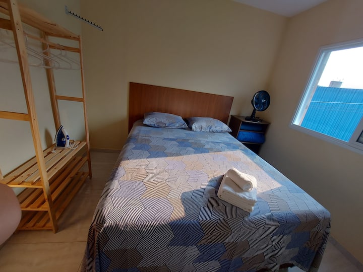 Letto matrimoniale, spogliatoio, cassettiera e specchio a figura intera nella camera da letto.